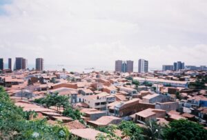 Image of Fortaleza city in Brazil, with slums in the foreground and taller high-rises in the background.