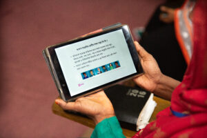 A community health worker is using a tablet to access an online training platform